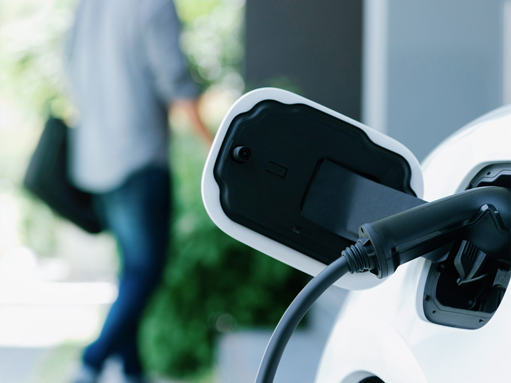 an image of a close up view of an EV charge cord plug into an EV